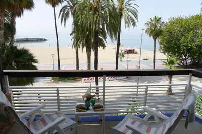 a balcony with chairs and a view of a beach at Fragata Beach Seaview in Sitges