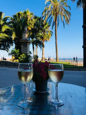two glasses of wine sitting on a table near the beach at Fragata Beach Seaview in Sitges