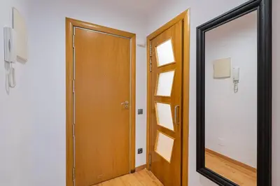 a mirror and a wooden door in a room at Lodging Apartments Villa de Gracia 2 bedroom cozy apartment in Barcelona