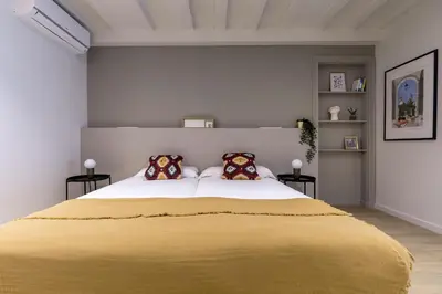 a bedroom with a large yellow bed with two pillows at Mirador 1840 in Barcelona