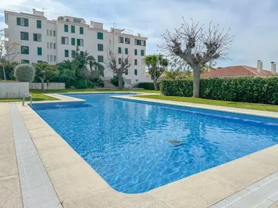a large blue swimming pool in front of a building at Balmins White by Hello Homes Sitges in Sitges