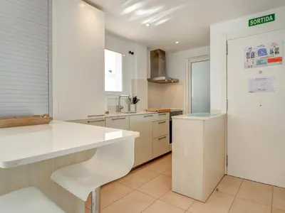 a kitchen with a white counter and a refrigerator at Balmins White by Hello Homes Sitges in Sitges