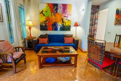 a living room with a blue couch and a table at Beach Apartment Garden Vinyet by Hello Homes Sitges in Sitges