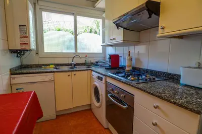 a kitchen with a sink and a washing machine at Beach Apartment Garden Vinyet by Hello Homes Sitges in Sitges