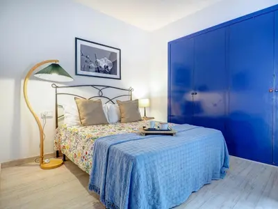 a bedroom with a bed with a blue headboard at Velero Attic by Hello Homes Sitges in Sitges