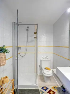 a bathroom with a shower with a toilet and a sink at Velero Attic by Hello Homes Sitges in Sitges