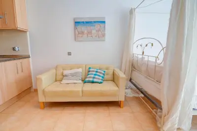 a living room with a couch with two pillows on it at The Loft by Hello Homes Sitges in Sitges