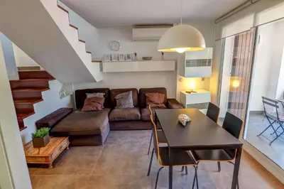 a living room with a couch and a table at Harbour terraces by Hello Homes Sitges in Sitges