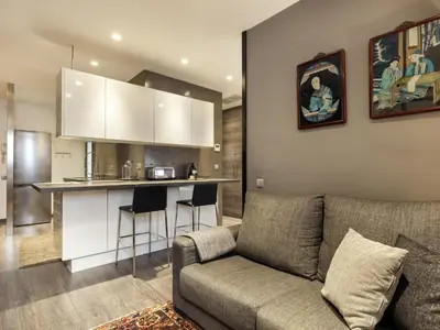 a living room with a couch and a kitchen at Click&Flat Luxury cabanyes in Barcelona