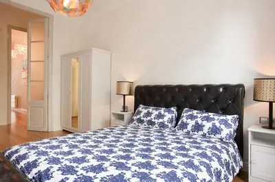 a bedroom with a bed with a blue and white comforter at LUXURY BARCELONA CENTRAL CITY COSY 3 BEDROOM APARTMENT WITH PRIVATE TERRACE in Barcelona