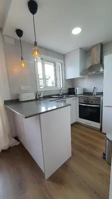 a kitchen with white cabinets and a counter top at Opening Doors Sagrada Familia in Barcelona
