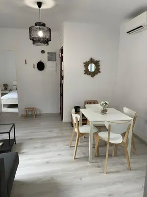 a dining room with a white table and chairs at Àtico lumineux à 10 min du centre ville in Hospitalet de Llobregat