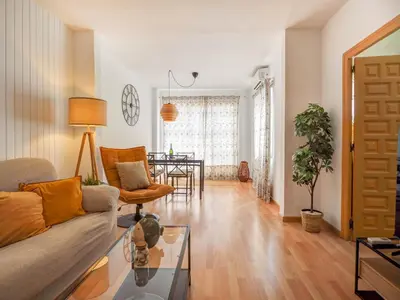 a living room with a couch and a table at Sebastian Terrace Apartment by Hello Homes Sitges in Sitges