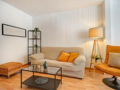 a living room with a couch and a table at Sebastian Terrace Apartment by Hello Homes Sitges in Sitges