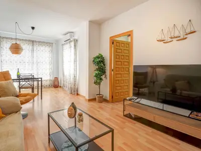 a living room with a couch and a table at Sebastian Terrace Apartment by Hello Homes Sitges in Sitges