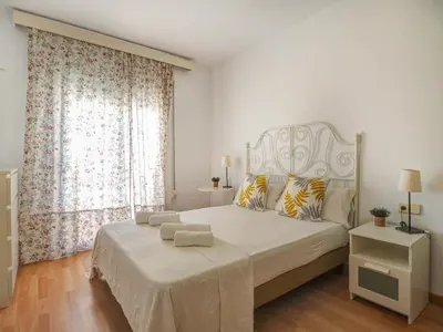a bedroom with a white bed with a large window at Sebastian Terrace Apartment by Hello Homes Sitges in Sitges