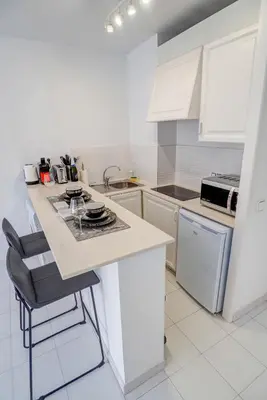 a kitchen with white cabinets and a counter top at White Penthouse by Hello Homes Sitges in Sitges