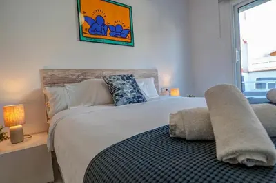 a bedroom with a large bed and a window at White Penthouse by Hello Homes Sitges in Sitges