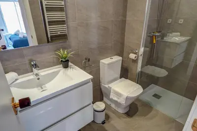 a bathroom with a sink and a toilet and a shower at White Penthouse by Hello Homes Sitges in Sitges