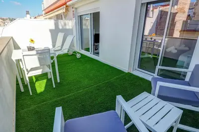 a small balcony with a table and chairs on it at White Penthouse by Hello Homes Sitges in Sitges