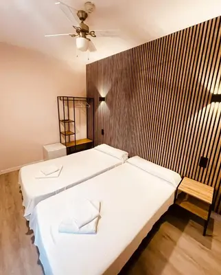 a bedroom with two beds and a wooden wall at COLIBRI in Calella