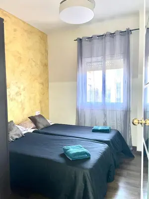 a bedroom with a bed with blue sheets and a window at APARTAMENTO BARCELONA in Barcelona