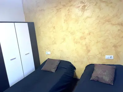 a bedroom with two beds and a dresser at APARTAMENTO BARCELONA in Barcelona