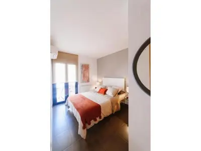 a bedroom with a bed and a mirror in it at Sitges Spaces Deluxe Beach Apartment- 3 Bedroom, 2 Bathroom, Next to Beach, Sleeps 6 in Sitges