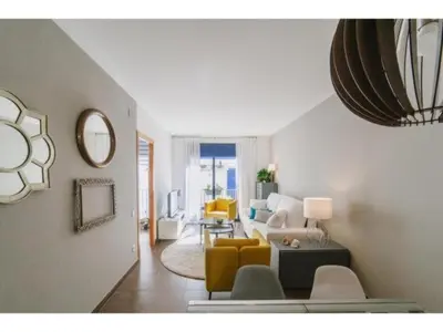 a living room with a couch and a table at Sitges Spaces Deluxe Beach Apartment- 3 Bedroom, 2 Bathroom, Next to Beach, Sleeps 6 in Sitges