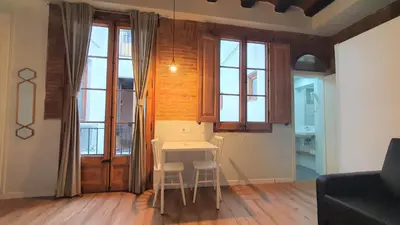 a living room with a table and two stools at Barrio Gotico Apartments Ferran in Barcelona