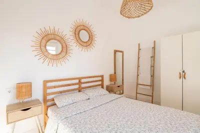 a bedroom with a bed and two mirrors on the wall at Apartamento NUEVO con encanto en SAGRADA FAMILIA in Barcelona