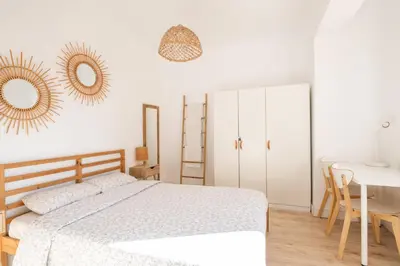 a bedroom with a bed and a desk and two mirrors at Apartamento NUEVO con encanto en SAGRADA FAMILIA in Barcelona