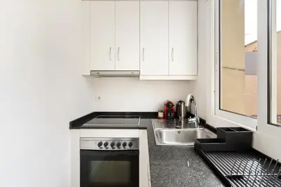 a kitchen with white cabinets and a sink at Lodging Apartments Barceloneta Beach Studio 42 in Barcelona