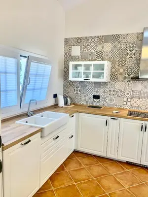 a kitchen with white cabinets and a sink at Bio Resort Mediterráneo in San Martín Sarroca