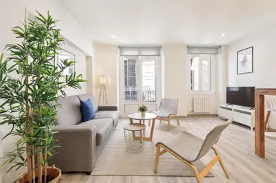 a living room with a couch and a tv at Sitges Group Blue&White in Sitges