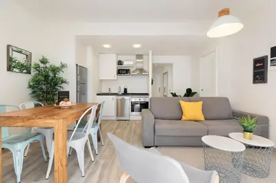 a kitchen and living room with a table and chairs at Sitges Group Blue&White in Sitges