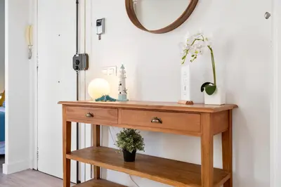 a wooden console table with a mirror on the wall at Lodging Apartments Barceloneta Beach Studio 32 in Barcelona