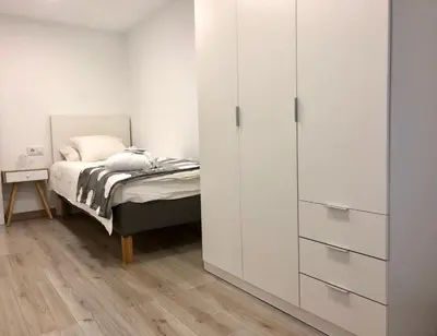 a bedroom with a bed and a white cabinet at MonResidence Cavall Bernat in Manresa