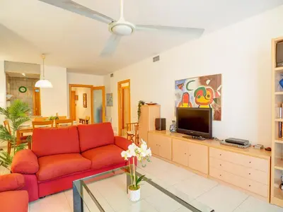 a living room with a red couch and a tv at Apartamento Burdeos by Hello Homes Sitges in Sitges