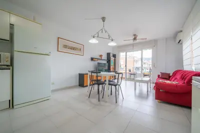 a living room with a red couch and a tv at HomeHolidaysRentals Margot - Costa Barcelona in Pineda de Mar