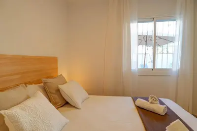 a bedroom with a bed with two pillows and a window at Sebastian Patio by Hello Homes Sitges in Sitges