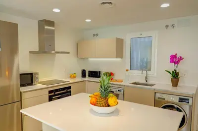 a kitchen with a bowl of fruit on a counter at Sebastian Patio by Hello Homes Sitges in Sitges