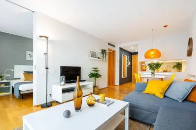 a living room with a blue couch and a white table at Lodging Apartments Monumumental in Barcelona