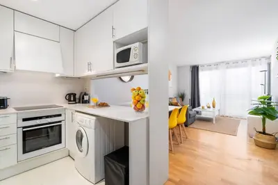 a white kitchen with a washer and dryer at Lodging Apartments Monumumental in Barcelona