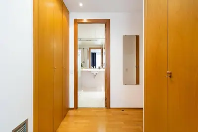 a hallway with a bathroom with a sink and a mirror at Lodging Apartments Monumumental in Barcelona