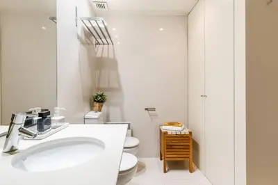 a white bathroom with a sink and a toilet at Lodging Apartments Monumumental in Barcelona