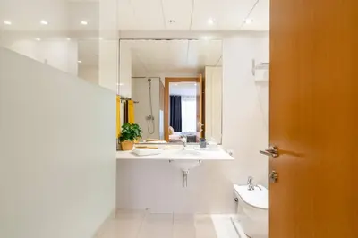 a bathroom with a sink and a toilet and a mirror at Lodging Apartments Monumumental in Barcelona