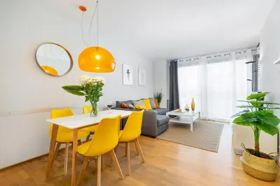 a living room with a table and yellow chairs at Lodging Apartments Monumumental in Barcelona