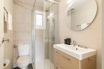 a bathroom with a toilet and a sink and a mirror at Collblanc Apartment by Olala Homes in Hospitalet de Llobregat