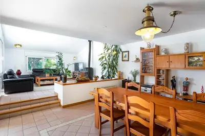 a kitchen and living room with a wooden table and chairs at Mediterranean villa with pool near barcelona in Cabrera de Mar